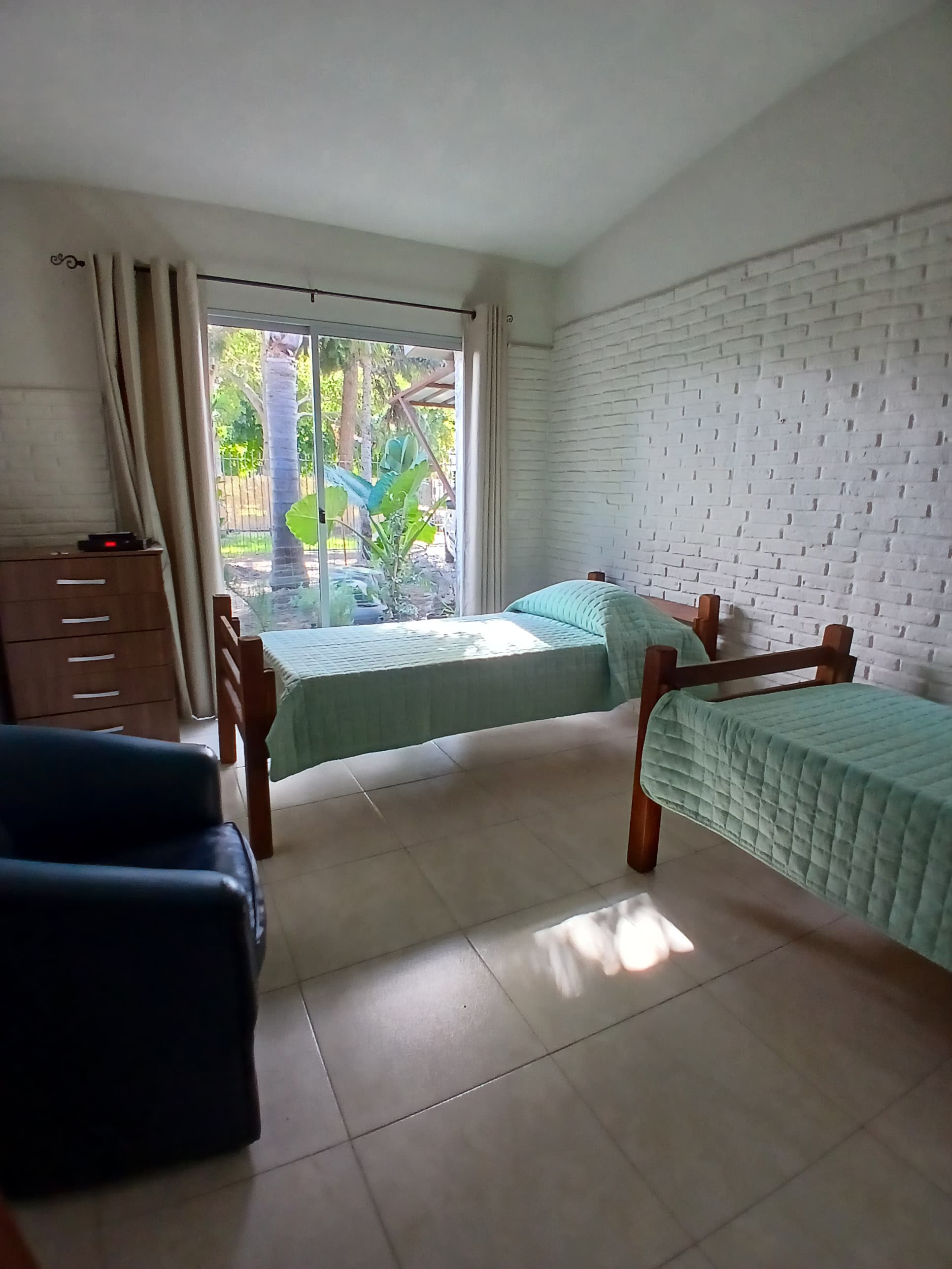 Habitación luminosa con dos camas y vista al jardín